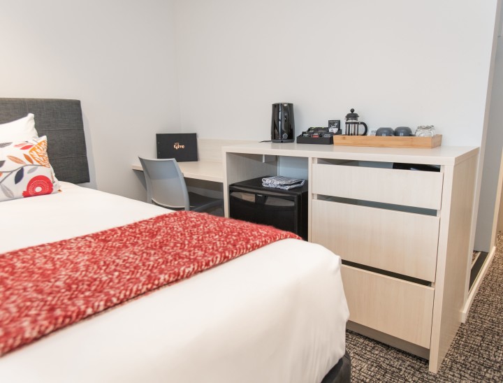 A bed, desk and kitchenette in a room at Hotel Give