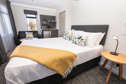 A bed, couch and kitchenette in an executive studio at Hotel Give